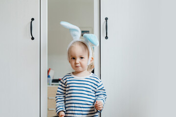 Smiling little boy wearing bunny ears on Easter day. Preschool children spending time at home or daycare
