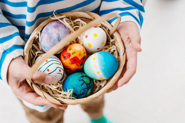 Colorful Easter eggs in basket. Kids hunt for eggs outdoors.