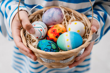 Colorful Easter eggs in basket. Kids hunt for eggs outdoors.