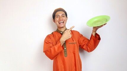 Asian Muslim man gesturing pointing to a plate in his hand with an enthusiastic expression