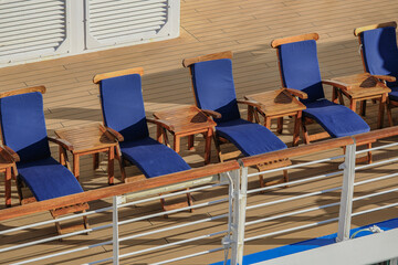 Deck chairs or sun loungers with table on balcony or terrace or patio of luxury modern cruise ship...