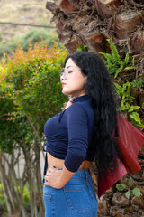 Retrato de una mujer blanca, latina, hermosa de cabello negro con chaqueta roja y una blusa azul,...