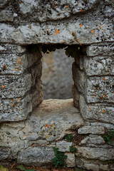 A stone archway in a rustic setting. The perspective from a distance gives a comprehensive view of this picturesque location.