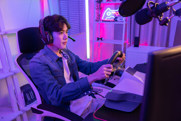 Male Esport Gamer with Car Steering Wheel Joy Controller playing driving simulator Online Video Game © charnsitr