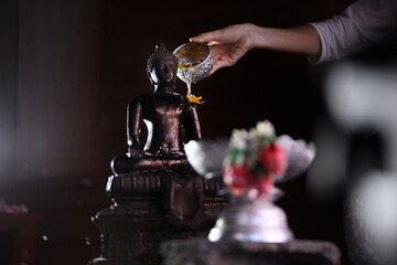 Sprinkle water to the statue of Buddha 