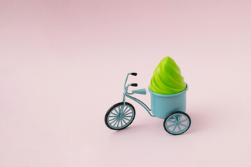Blue vintage ice cream bicycle on pink background. Creative food concept.