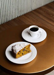 Still life shot of a candy cake with a cup of coffee on a table