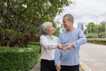 Couple in the park near home to relax, health and exercise in love sports, old man and senior woman taking a walk outdoors together in the morning