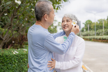 Obraz premium Couple in the park near home to relax, health and exercise in love sports, old man and senior woman taking a walk outdoors together in the morning