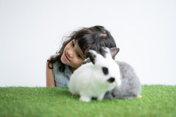 Smiling little girl and with their beloved fluffy rabbit, showcasing the beauty of friendship between humans and animals