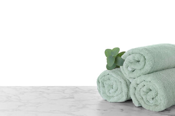Fresh towels and eucalyptus branch on marble table against white background. Space for text
