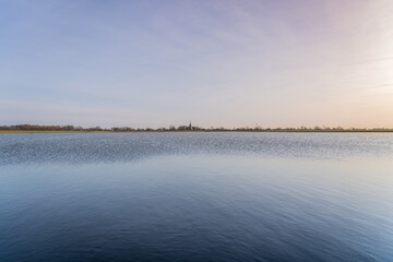Tranquil scene over a dutch village lake with overflowing water Into the meadow. Sky above...