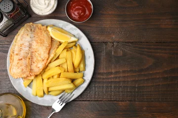 Poster Delicious fish and chips served on wooden table, flat lay. Space for text © New Africa