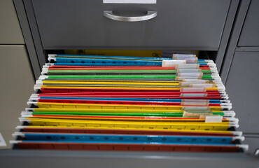 Abstract background image of colorful hanging file folders in drawer.