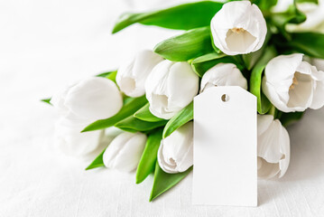 bouquet of fresh white tulips and blank card on Mothers day or Womens day. Top view with copy space Floral composition Romantic background - 746607012