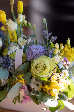 a beautiful delicate spring bouquet of daffodils and eustom. floral arrangement in yellow green and purple	
