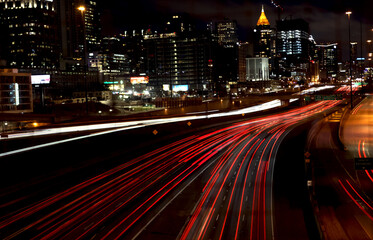 Fototapeta na wymiar Atlanta highway and buildings at night displaying light-trails. Dynamic photo of car motion in Atlanta Georgia
