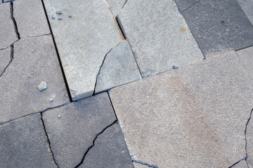 Broken sidewalk tile or rectangular pavement stone for illustrating concepts related to urban...