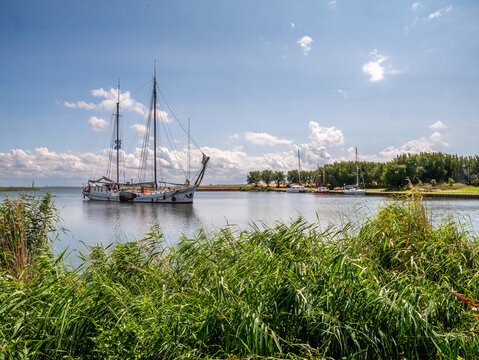 Two-masted sailing ship entering harbour of Trintelhaven on Houtribdijk between Lelystad and Enkhuizen, Netherlands