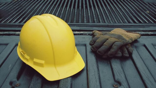 Hard hat and work gloves on pickup truck bed