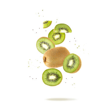 Fresh ripe kiwi green fruit whole and slices with drops and seeds falling flying isolated on white