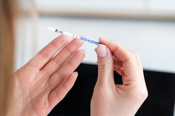 A woman holds a pregnancy test with a positive result