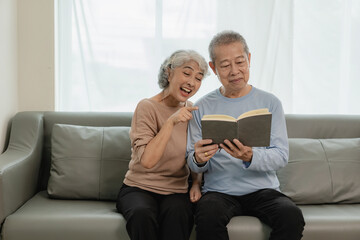 Asian senior couple looking at camera and smiling, senior smiling and looking at tablet Retired...