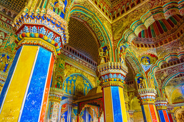 Thanjavur, Tamil Nadu, India - The high arches artworks and colorfully painted wall murals and ceilings of the ancient 17th-century durbar hall Maratha Palace in the town of Thanjavur.
