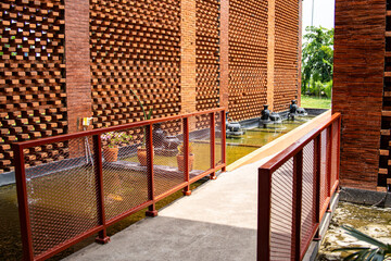 Fototapeta premium Exposed red brick facade with pond and small fountains.