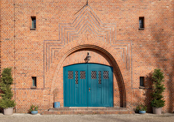 Mit unterschiedlichen Ziegeln expressionistisch gestaltetes Portal der denkmalgeschützten katholische Kirche 