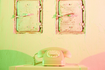 old telephone with a separate receiver and rotary dial on a board in front of two chimney flaps,...