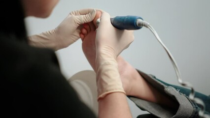 A pedicure master does cleaning and massage, pedicure, to a young beautiful girl with a small foot. Caring for female beauty in a beauty salon during a procedure. Skin of feet and toes close-up