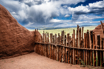 Old adobe brick wall and stick fence in desert
