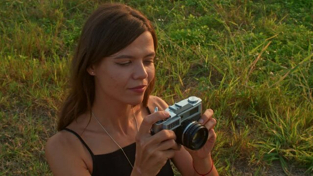 Young woman with a retro camera in nature