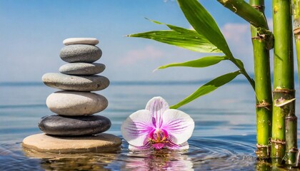 Obraz na płótnie Canvas a stack or pyramid of stones bamboo and an orchid in the water balancing pebble stone concept of relaxation equilibrium