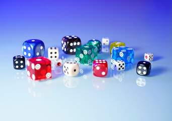 Dice in various sizes and colors on the table with reflection