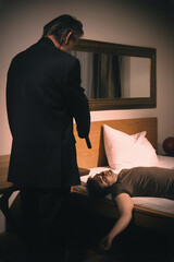 Old member of criminal  gang shooting victim in hotel room - obrazy, fototapety, plakaty