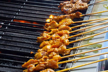 Asian cuisine, Malaysia chicken satay cooking on a hot charcoal grill.