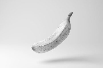 White ripe banana with black dots floating in mid air on white background in monochrome and minimalism. Illustration of the concept of food,  fruits, nutrients and vitamins