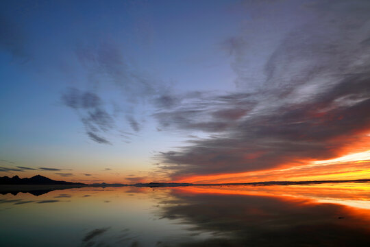 Colorful sunrise at Bonneville Salt Flats with spectacular water reflection near Wendover in Utah, United States