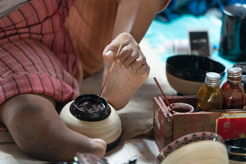 burmese man painted handicraft with foot
