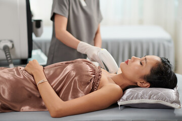 Vietnamese woman getting her armpit hair laser epilation in beauty salon