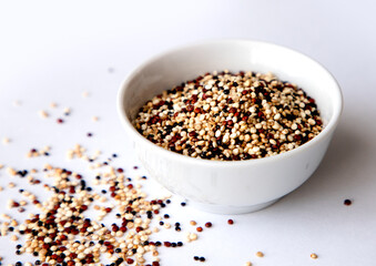 Organic Tri-Color Quinoa in a White Ceramic Bowl. Healthy Eating Concept.