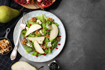 Delicious pear salad served on dark textured table, flat lay. Space for text