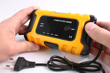 A man gets acquainted with the functions and capabilities of a multi-functional charger.