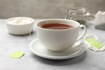 Fototapeta na wymiar Brewing tea. Cup with tea bag on light table