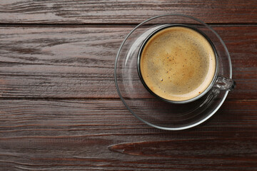 Cup of aromatic coffee on wooden table, top view. Space for text