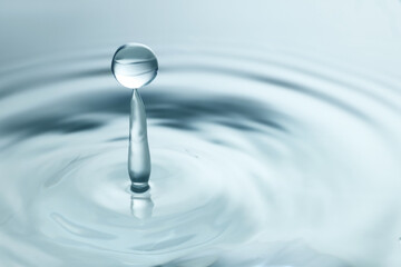 Fototapeta na wymiar Splash of clear water with drop on light grey background, closeup