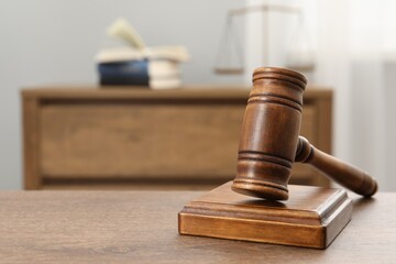 Wooden gavel and sound block on table indoors, closeup. Space for text