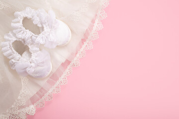 Christening background with baptism baby shoes on pink background